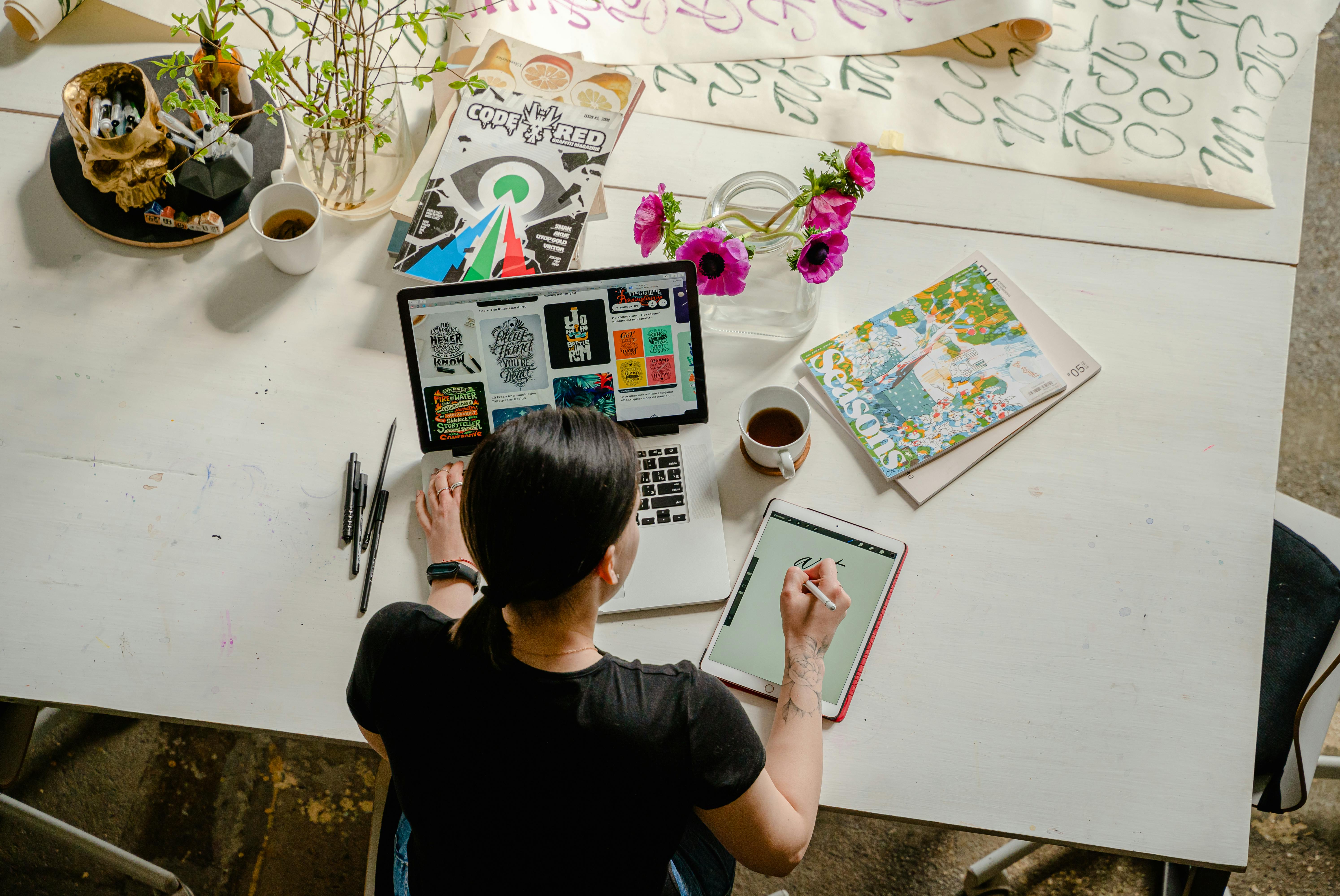 creating a user-centric app on a desk with a laptop and a tablet and a coffee