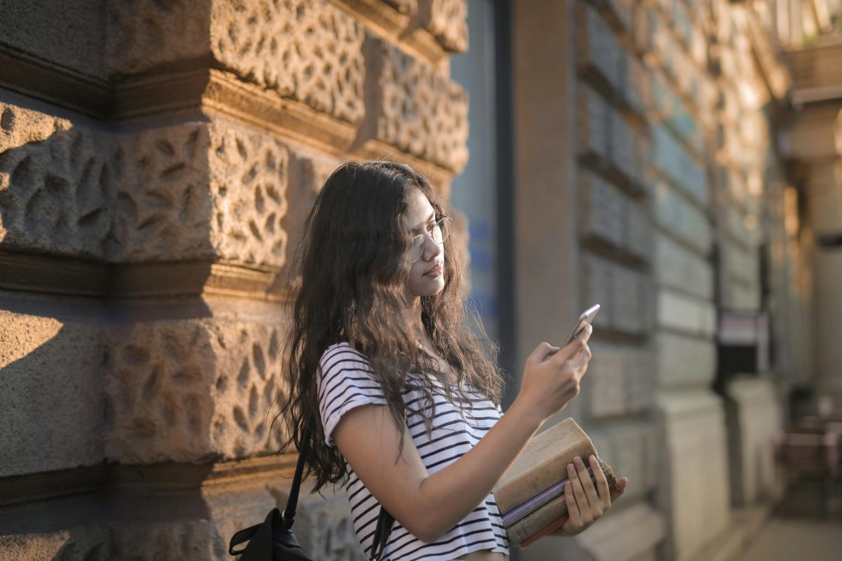 educational app student girl with phone on a street