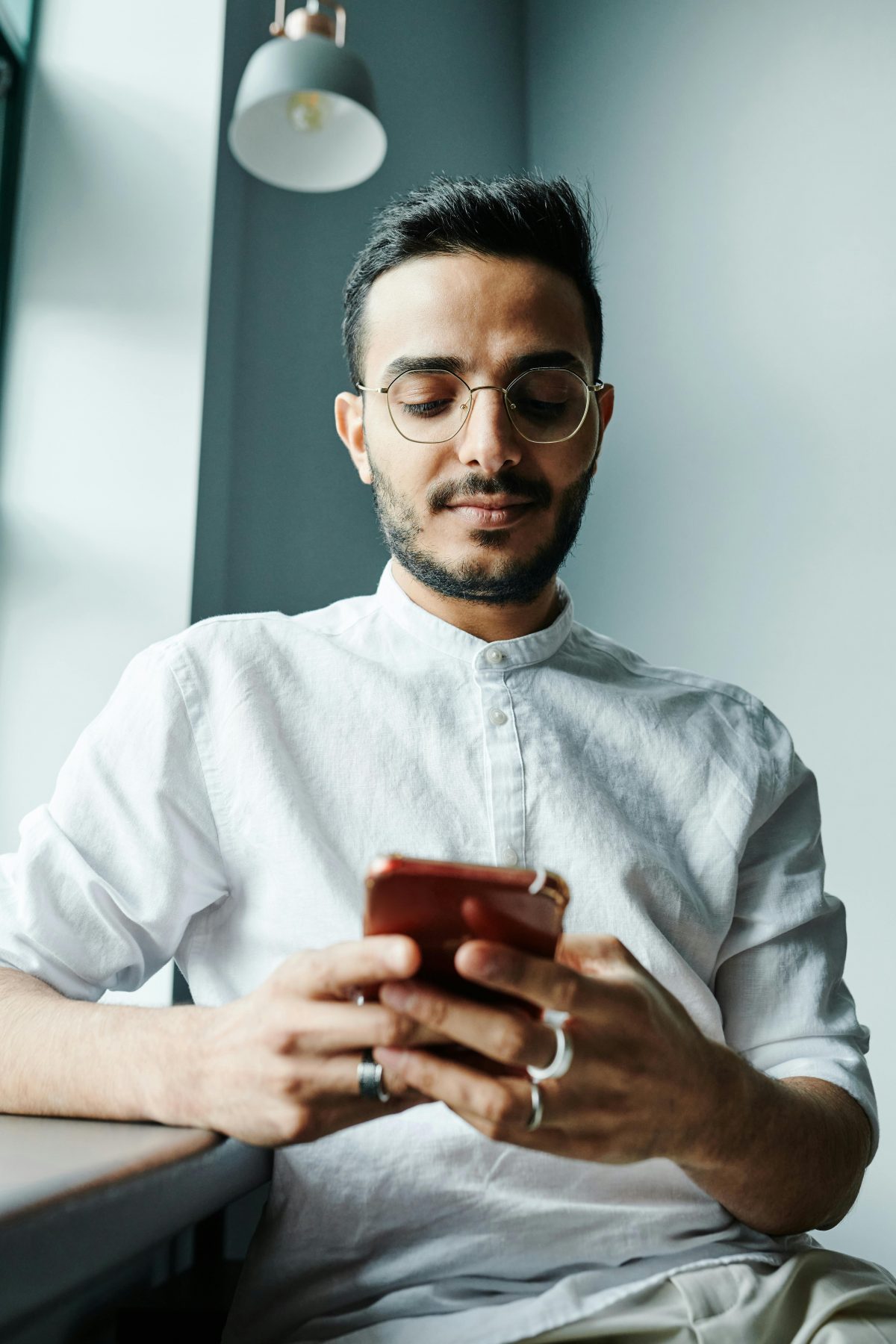 man in glasses with a phone smiling