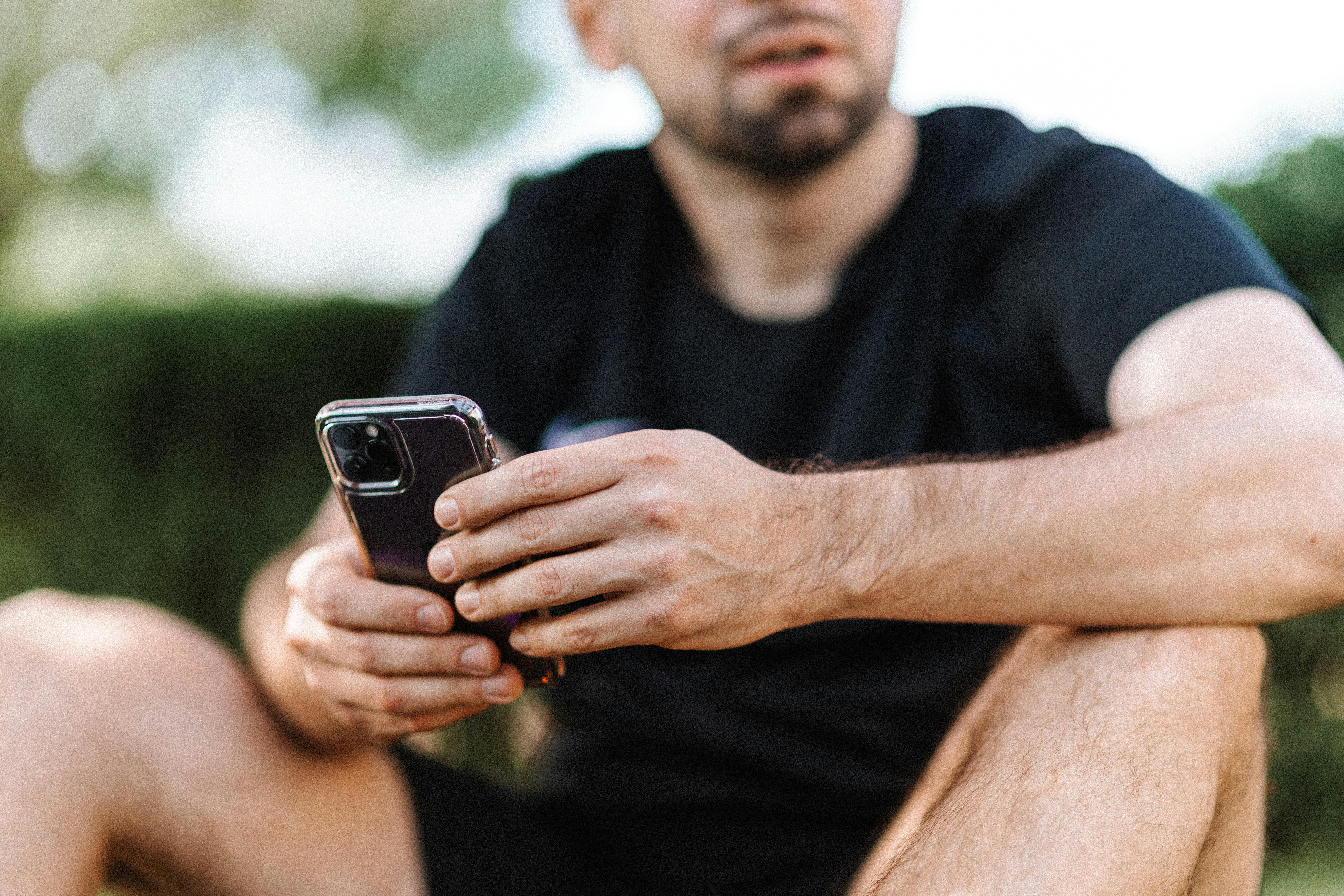 guy with a phone in hands black tshirt