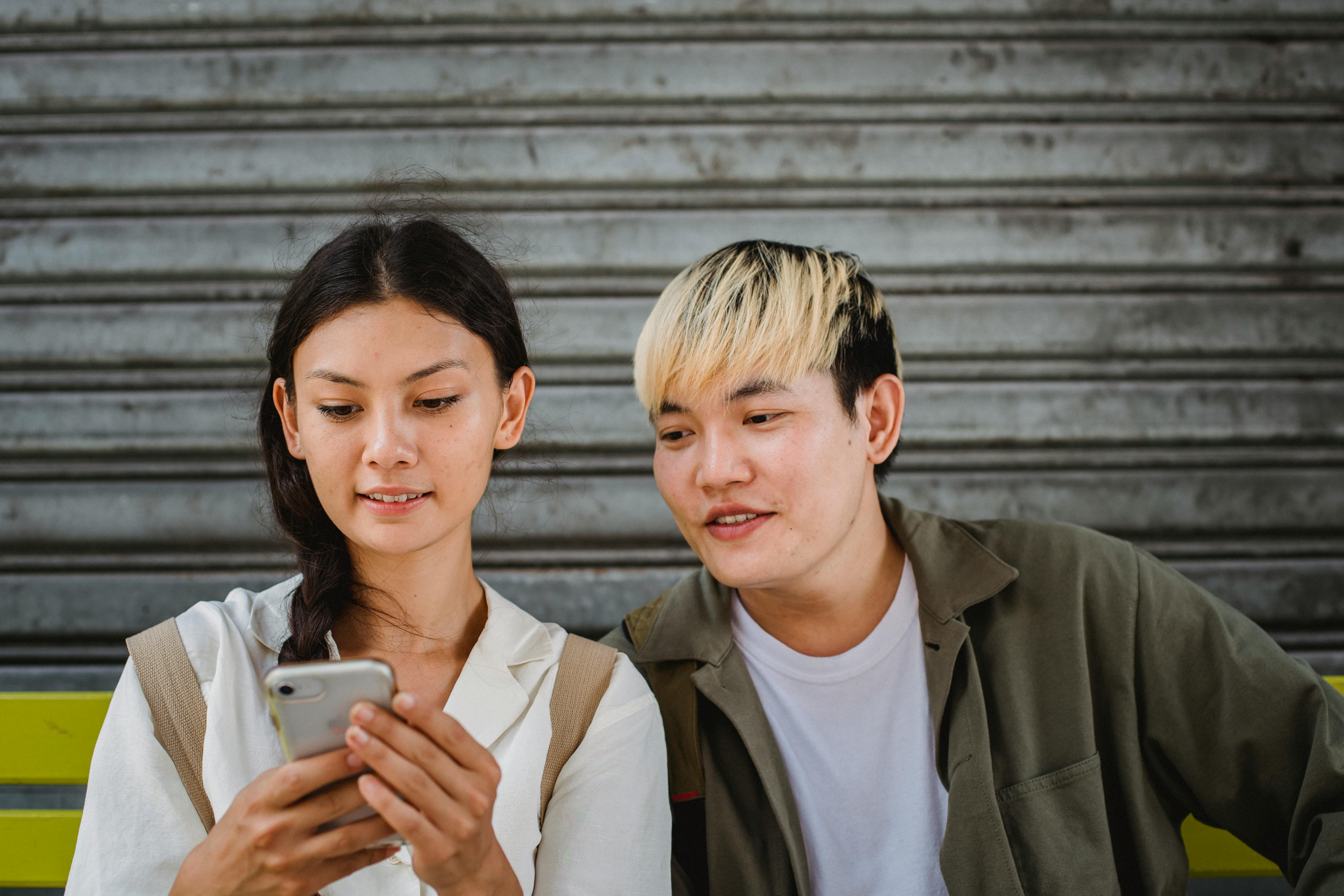 two teenagers looking at the phone app 