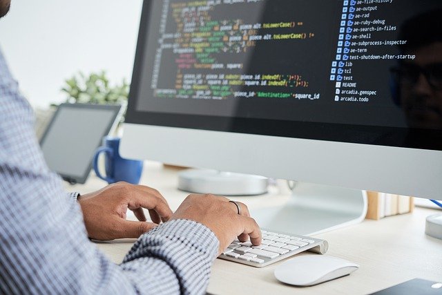 hands typing on keyboard coding seeing the code on the sereen
