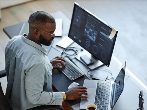 black developer man working with two screens